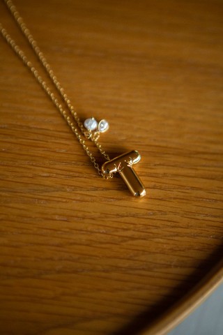 Colar dourado com a letra T